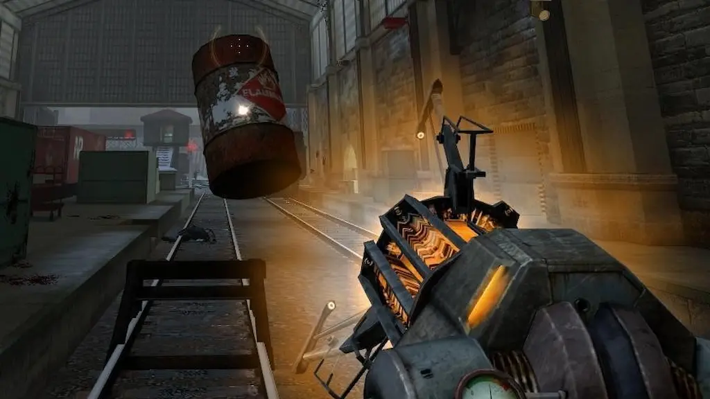 First-person view of the Gravity Gun in Half-Life 2 levitating a red explosive barrel over industrial railway tracks.