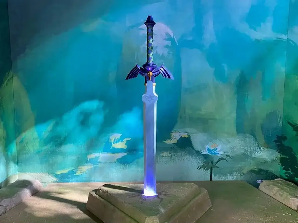 Master Sword from The Legend of Zelda glowing blue in a stone pedestal against a painterly background.
