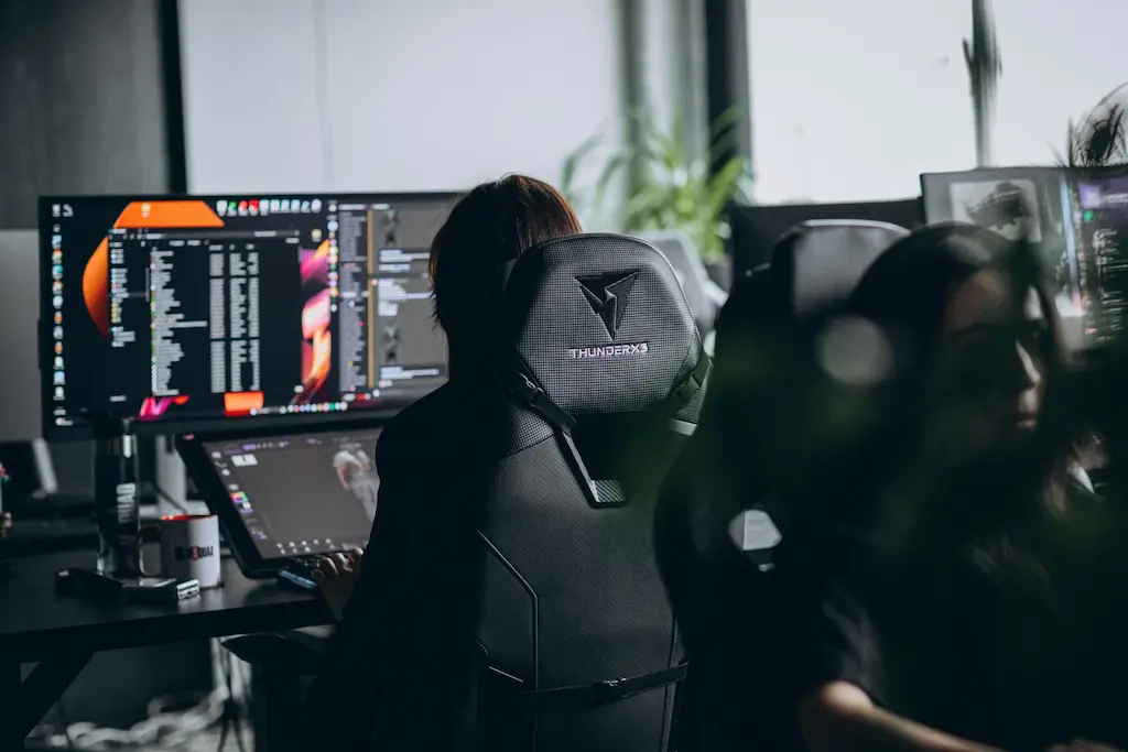 2D artists working in a professional game studio environment with specialized digital workstations.