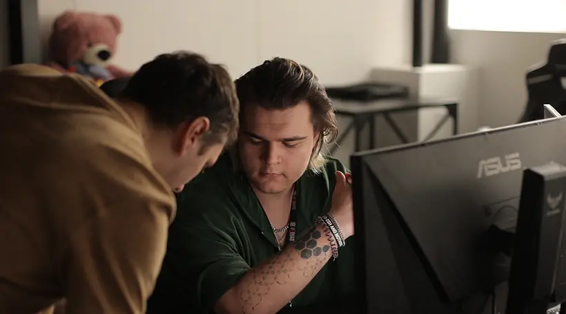 Game developers analyzing code and performance for HTML5 game optimization and QA testing.