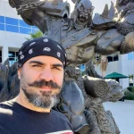 Ancelmo Toledo posing in front of the Blizzard Entertainment Orc statue