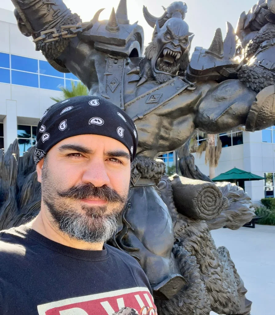 Ancelmo Toledo posing in front of the Blizzard Entertainment Orc statue
